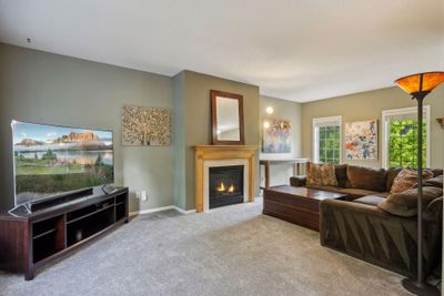 The living room has a cozy gas fireplace | Image 2