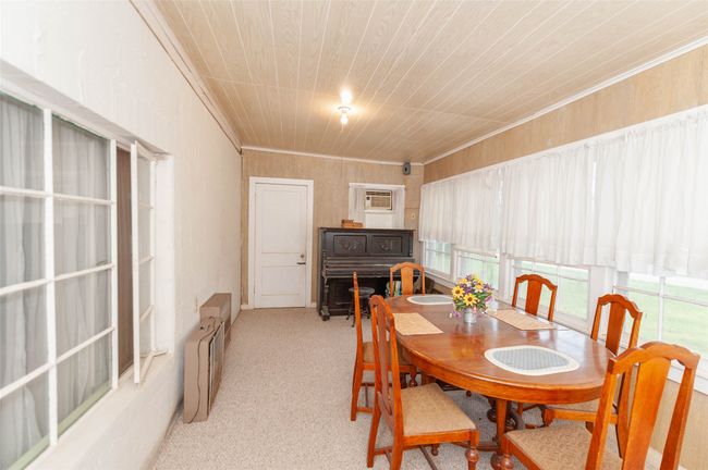 Dining area featuring a wall mounted air conditioner, light colored carpet, and crown molding | Image 20
