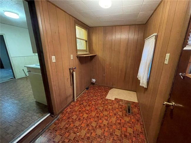 Laundry room featuring wood walls | Image 8