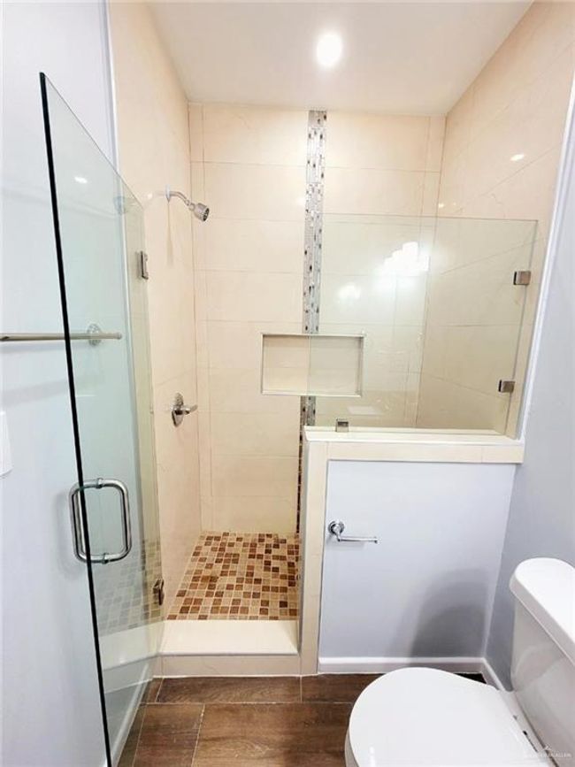 Bathroom with a shower stall, toilet, and wood finished floors | Image 10