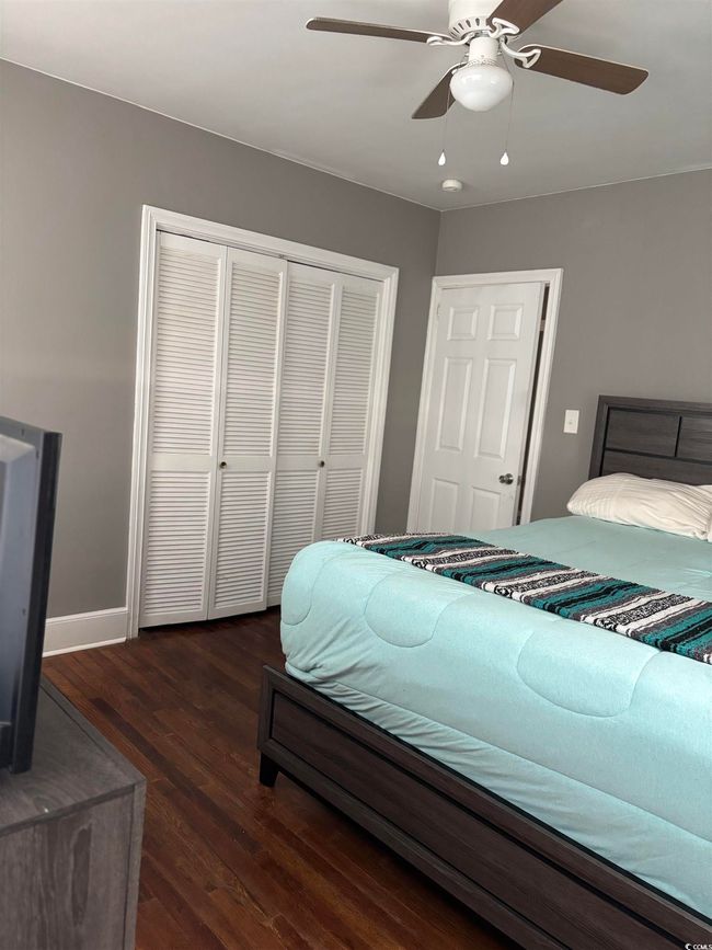 Bedroom with a closet, dark wood-style flooring, baseboards, and a ceiling fan | Image 21