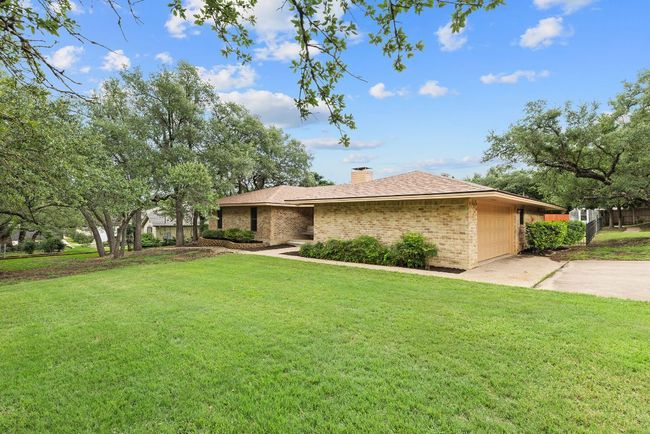 View of front of house with driveway, a front yard, an attached garage, and brick siding | Image 36