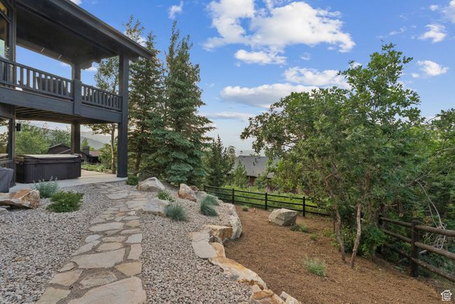 View of yard with a hot tub, a wooden deck, and a patio area | Image 79