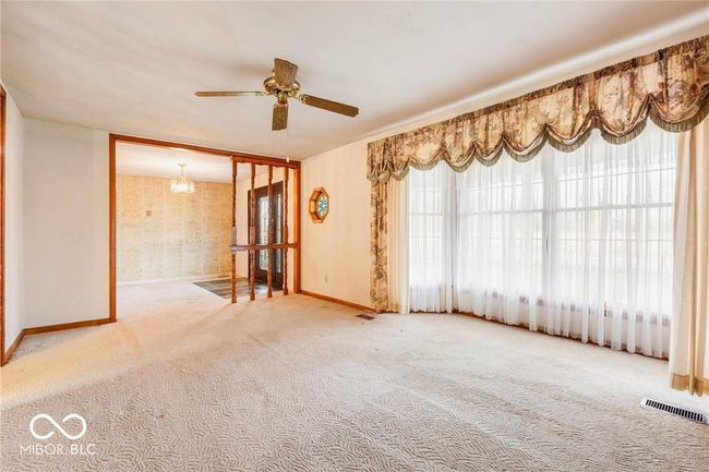 spare room featuring carpet flooring, a ceiling fan, and a chandelier | Image 19