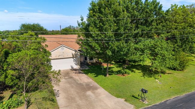 View of front of property featuring concrete driveway, a front yard, a garage, and stone siding | Image 34