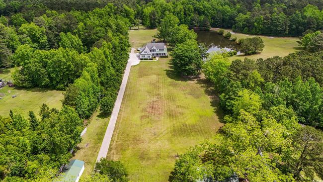 Aerial view of property and surrounding area with a heavily wooded area and a large body of water | Image 4