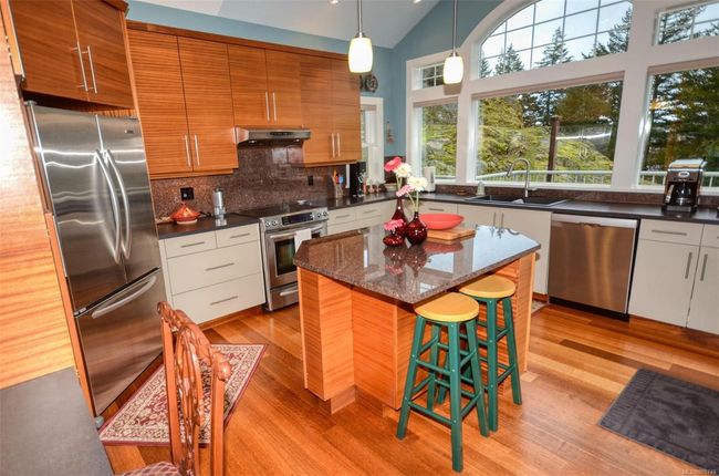 Very bright kitchen with contrasting colour upper and lower cabinets and an Island for casual dining | Image 9