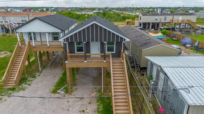 A striking aerial perspective highlights the home’s elevated profile and bold contrast in exterior finishes, with the front porch crowning the staircase and beckoning guests toward the entry. | Image 31