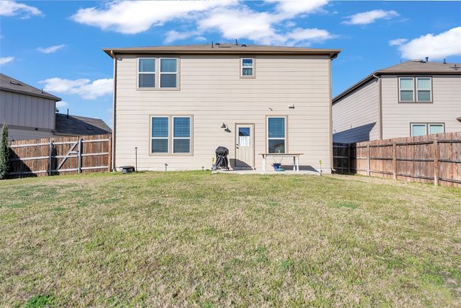 Rear view of house with a fenced backyard, a yard, and a gate | Image 26