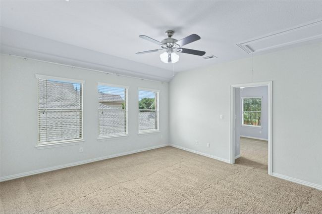 Empty room featuring attic access, light colored carpet, ceiling fan, and healthy amount of natural light | Image 20