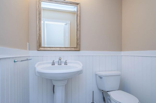 Bathroom featuring toilet, a sink, and wainscoting | Image 8