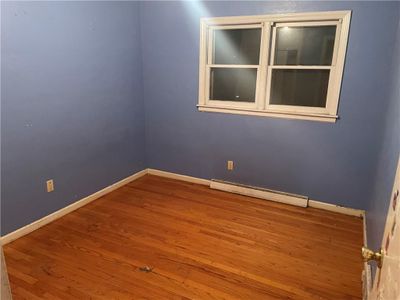 Unfurnished room with hardwood / wood-style flooring and a baseboard radiator | Image 3