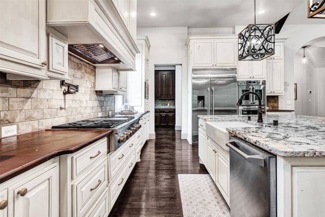 Yes, that's a 6 burner professional gas cooktop with a built-in griddle! What you can't see is the 2 spice drawers and garbage cabinet! What other surprises might there be? | Image 6
