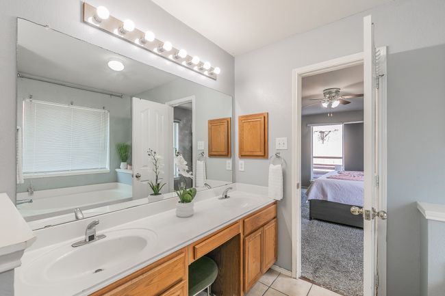 Ensuite bathroom with double vanity, tile patterned flooring, a ceiling fan, and a garden tub | Image 22