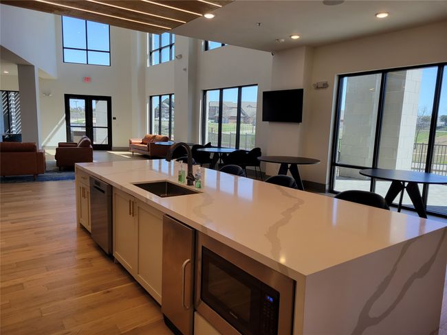 Kitchen with open floor plan, light wood-type flooring, white cabinetry, a kitchen island with sink, and healthy amount of natural light | Image 28