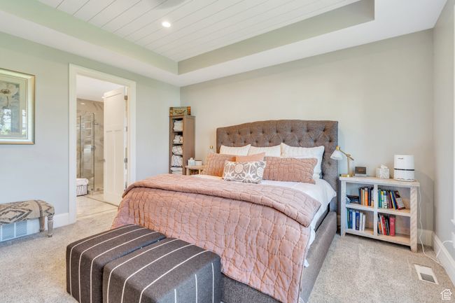 Carpeted bedroom with recessed lighting, a raised ceiling, connected bathroom, and wooden ceiling | Image 30