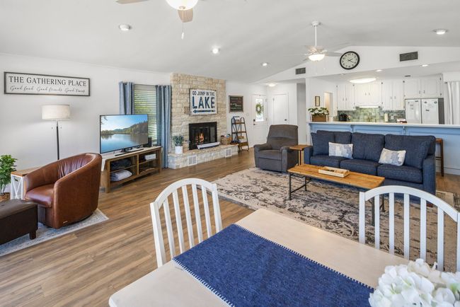 Living room with ceiling fan, visible vents, wood finished floors, and vaulted ceiling | Image 28