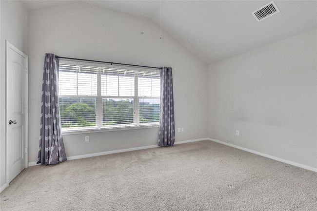 The bedroom has natural color walls, carpet and ceiling fan. | Image 8