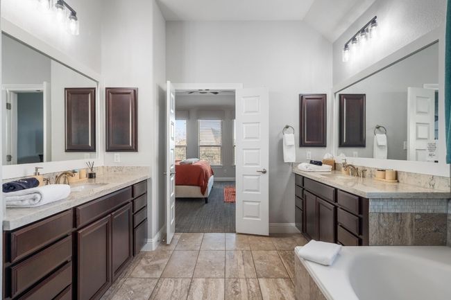 You won't want to leave this spa-like primary bathroom that takes getting ready for the day to a whole new level. Modern vanity lights, high ceilings, understated yet classic tile flooring are all featured here. | Image 26
