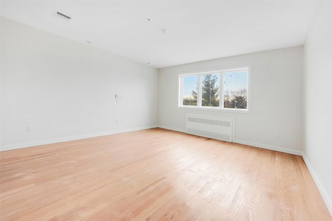 Spare room featuring light wood-type flooring and radiator | Image 44