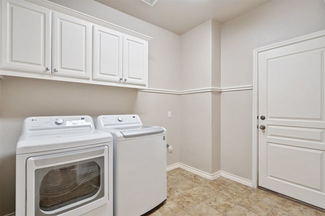 The laundry room includes built-in cabinets that provide ample storage for all your laundry essentials. With easy access from the main living areas, it’s the perfect blend of practicality and convenience. | Image 40