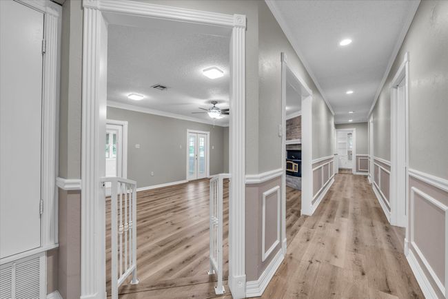 Corridor featuring light wood-style flooring, ornamental molding, and recessed lighting | Image 11