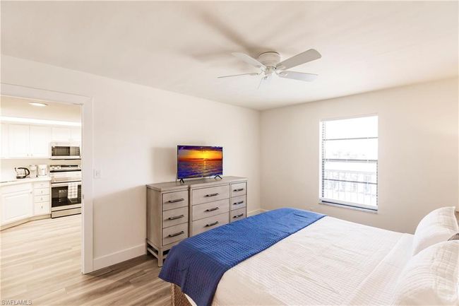 Bedroom with light wood-style flooring, baseboards, and ceiling fan | Image 15