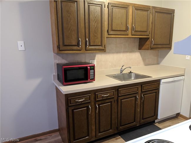 Kitchen with sink, dishwasher, hardwood / wood-style floors, and backsplash | Image 16