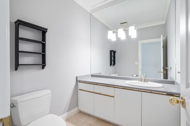 Half bath with ornamental molding, toilet, tile patterned flooring, and vanity | Image 18