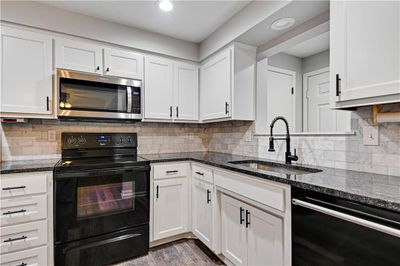 Renovated kitchen with granite countertops & white cabinets | Image 1