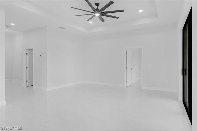 Spare room featuring ceiling fan and a tray ceiling | Image 29