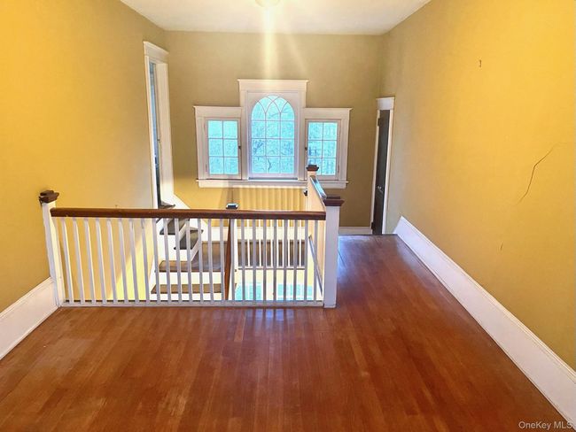 Hall featuring an upstairs landing, wood finished floors, and baseboards | Image 10