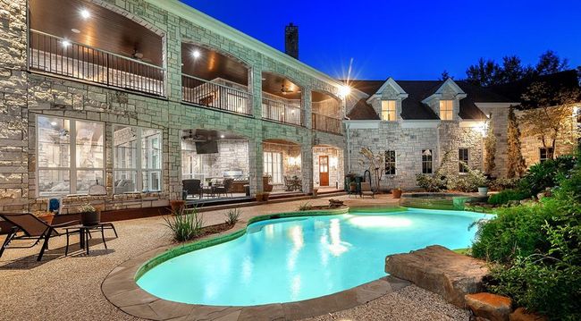 The heated pool and spa are surrounded by lush landscaping. Notice the diving rock! | Image 44