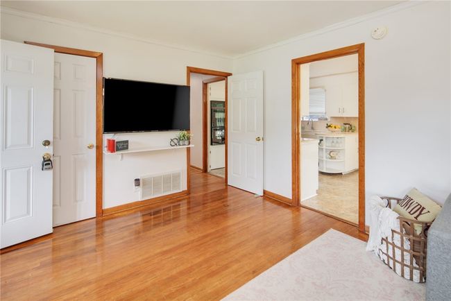 Living area featuring wood finished floors and crown molding | Image 6