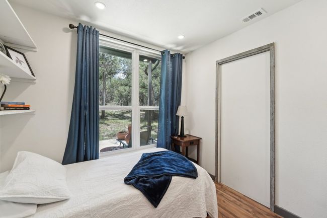 Bedroom with wood finished floors and recessed lighting | Image 15