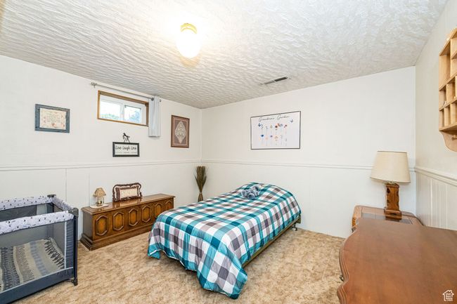 Carpeted bedroom with a textured ceiling and visible vents | Image 36