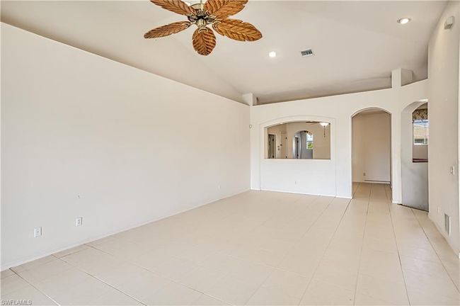 Carpeted bedroom with ceiling fan, connected bathroom, and a textured ceiling | Image 13
