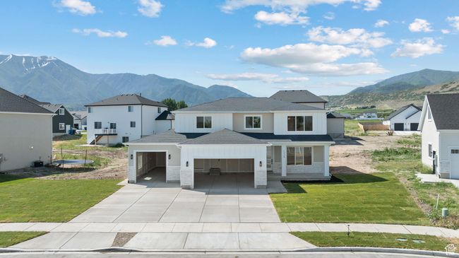 View of front of house with a mountain view, a garage, driveway, and a front yard | Image 46
