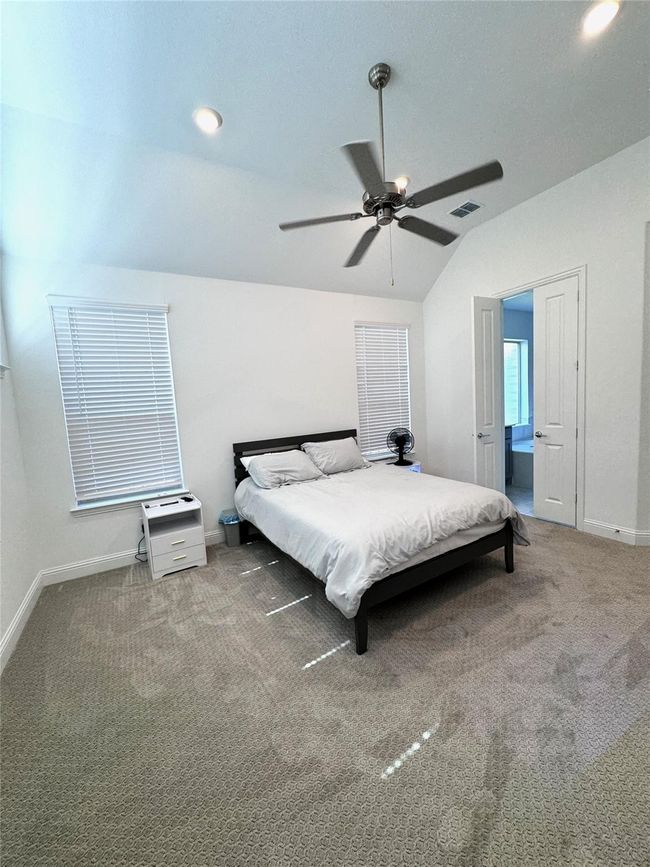 Carpeted bedroom with vaulted ceiling, ceiling fan, and recessed lighting | Image 6
