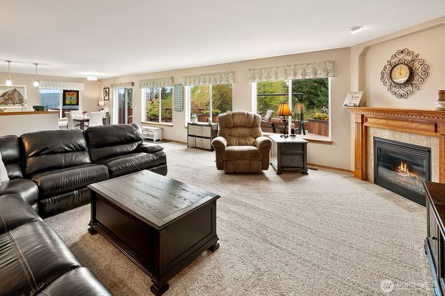 Gas fireplace warms up this cozy space. Large windows allow the natural light to flow in and provide peaceful, gorgeous views of the green belt and valley. | Image 11