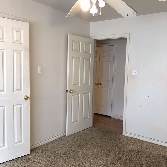 Unfurnished bedroom with carpet floors, ceiling fan, and baseboards | Image 9
