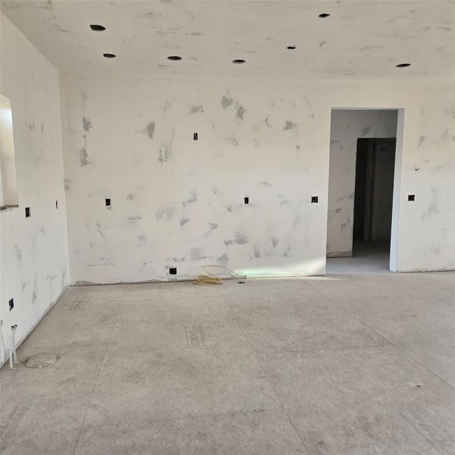 Living room with high vaulted ceiling, a stone fireplace, and beamed ceiling | Image 7