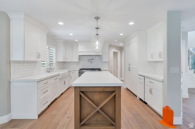 Kitchen featuring a sink, light countertops, light wood-style floors, and recessed lighting | Image 12