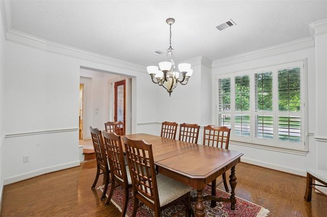 The formal dining room is just to your left as you enter the home. It has rich hardwood floors, crown molding and a chair rail. | Image 8