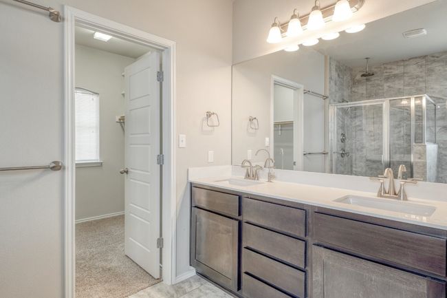 Bathroom with a stall shower, double vanity, and a walk in closet | Image 20