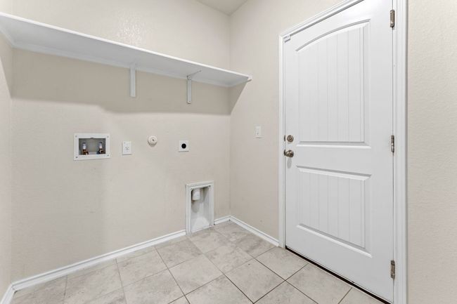 Washroom featuring washer hookup, electric dryer hookup, hookup for a gas dryer, and light tile patterned floors | Image 26