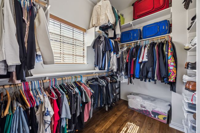 Oversized walk-in closet offers ample hanging space, built-in shelving, and natural light. | Image 23