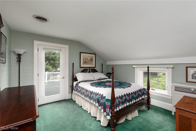 Bedroom featuring access to outside, lofted ceiling, carpet, and multiple windows | Image 32