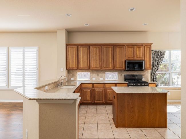 The kitchen is large, and has room for a breakfast table at the window to the right of the picture. | Image 8
