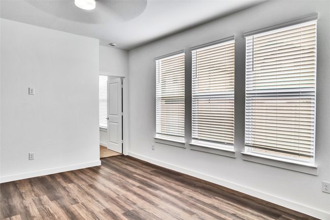 Unfurnished room featuring ceiling fan, wood finished floors, and baseboards | Image 5